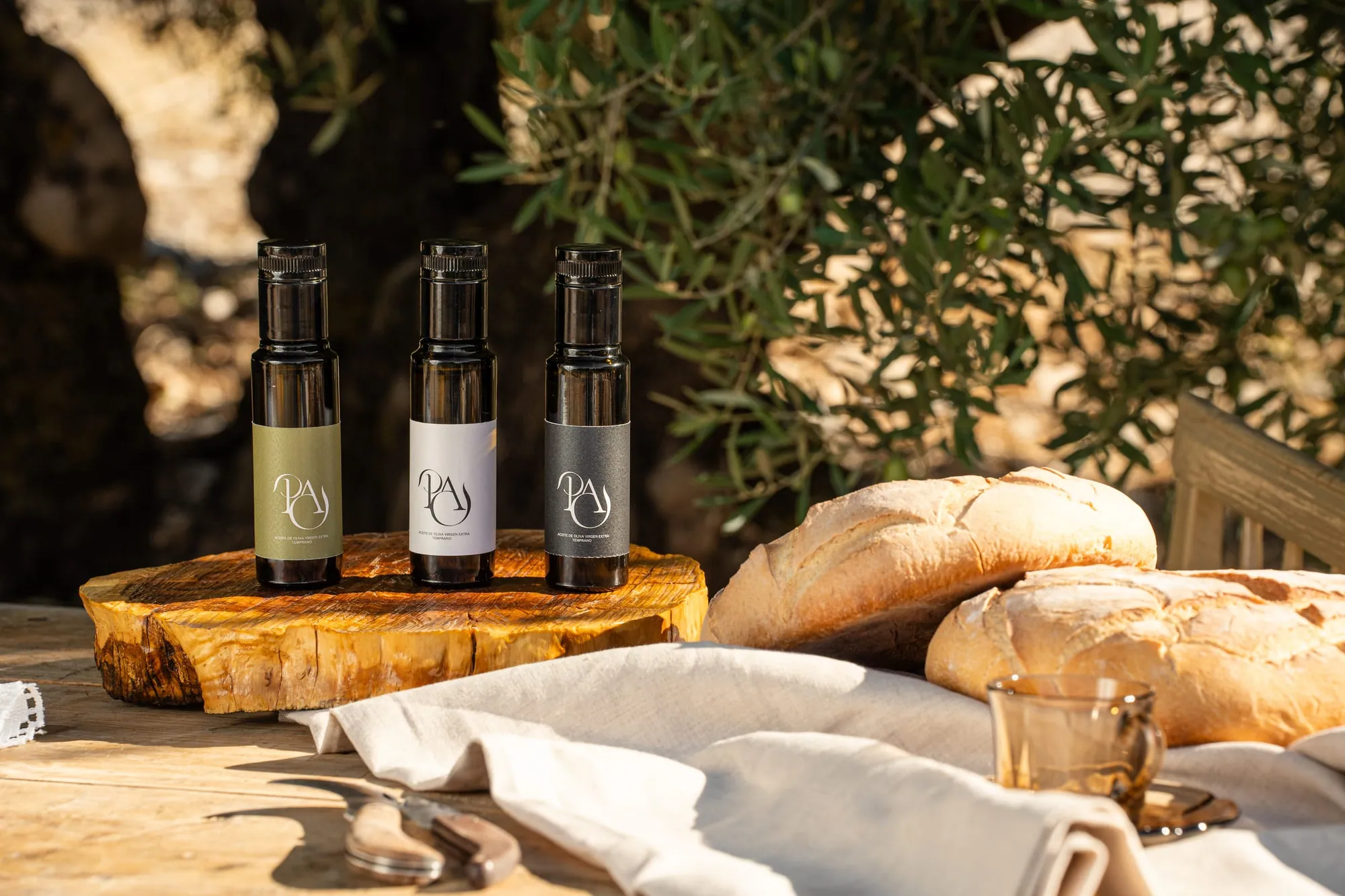 Tres botellas de 100 ml, una por cada aceite, junto a pan y lino